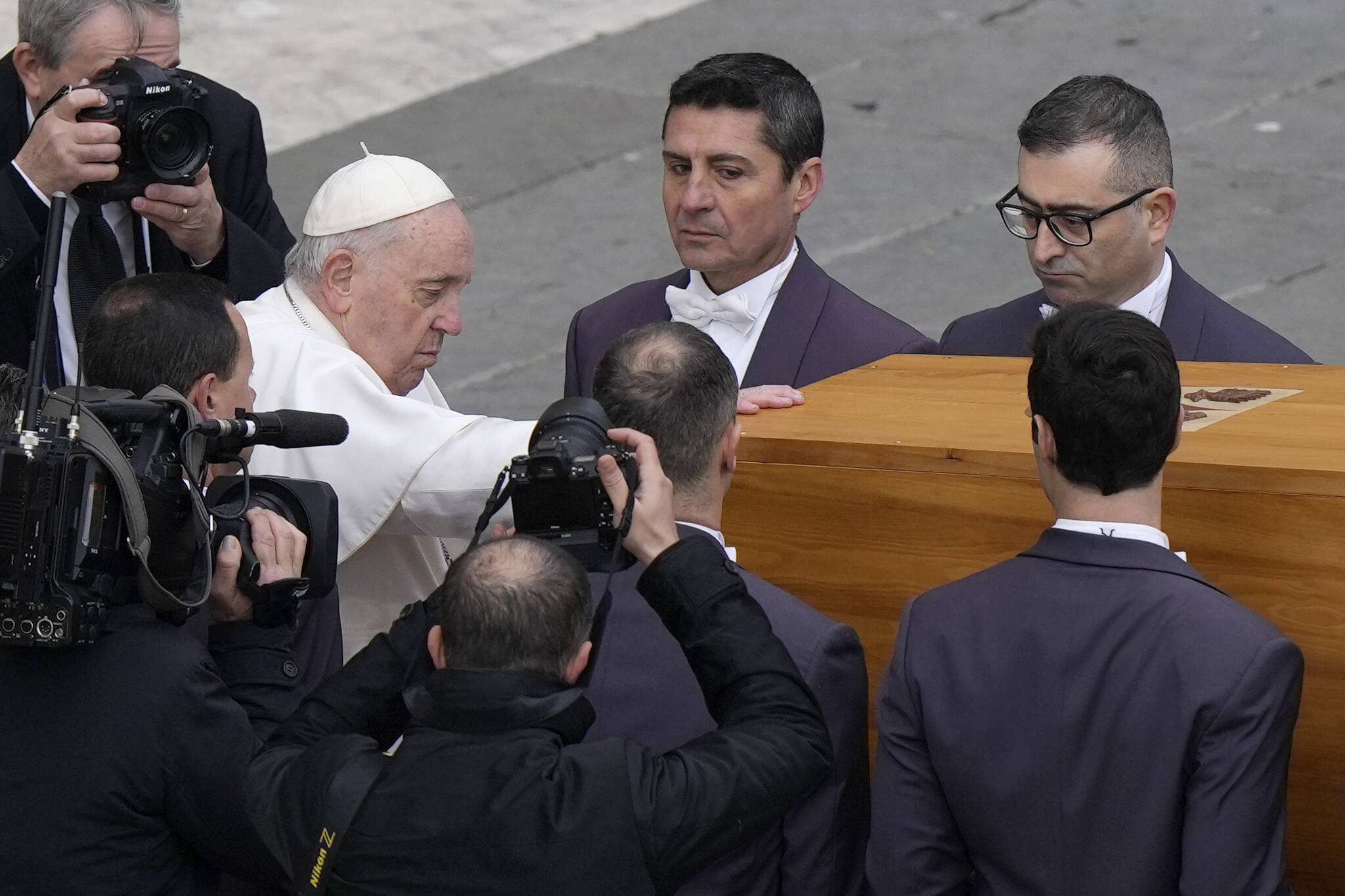 Pope Francis touches the coffin of late Pope Emeritus Benedict XVI before it is carried away after a funeral mass in St. Peter’s Square at the Vatican, Thursday, Jan. 5, 2023. Benedict died at 95 on Dec. 31 in the monastery on the Vatican grounds where he had spent nearly all of his decade in retirement. (AP Photo/Ben Curtis)