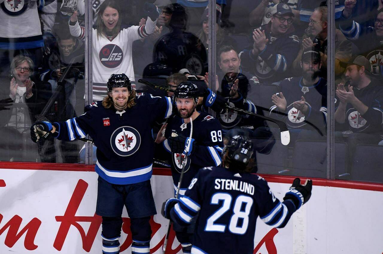 Winnipeg Jets’ Axel Jonsson-Fjallby (71) celebrates his goal against the Vancouver Canucks with Sam Gagner (89) and Kevin Stenlund (28) during second period NHL action in Winnipeg on Sunday January 8, 2023. THE CANADIAN PRESS/Fred Greenslade