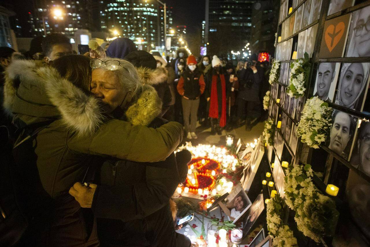 Akram Shojae (second right) is comforted at a vigil in Toronto on Saturday, Jan. 8, 2022 as she mourns her son, Amir Hossein Ovaysi, daughter-in-law Sara Hamzeei and grandchild Asal Ovaysi, who were among the 176 victims of Ukraine International Airlines Flight PS752 that was shot down in Iran in 2020. THE CANADIAN PRESS/Chris Young