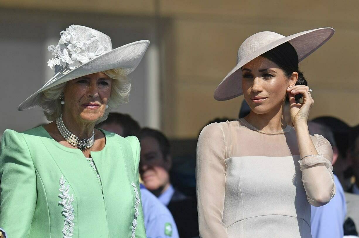 FILE - Meghan, the Duchess of Sussex, right, stands with Camilla, the Duchess of Cornwall, during a garden party at Buckingham Palace in London, Tuesday May 22, 2018. Britain’s Prince Harry has defended his memoir that lays bare rifts inside Britain’s royal family. He says in TV interviews broadcast Sunday that he wanted to “own my story” after 38 years of “spin and distortion” by others. (Dominic Lipinski/Pool Photo via AP, File)