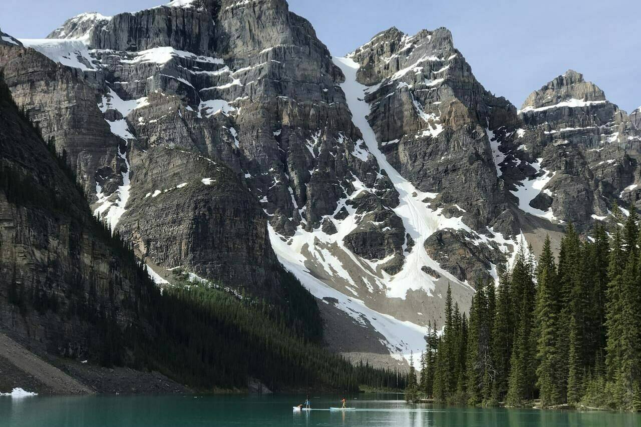 Paddle boarders are seen on Moraine Lake in Lake Louise, Alta., in June 2020. THE CANADIAN PRESS/Jonathan Hayward