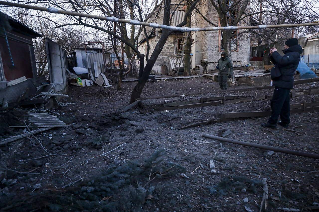 Investigators inspect a site of a damaged part of an house after what Russian officials in Donetsk said it was a shelling by Ukrainian forces, in Donetsk, in Russian-controlled Donetsk region, eastern Ukraine, Tuesday, Jan. 10, 2023. (AP Photo)