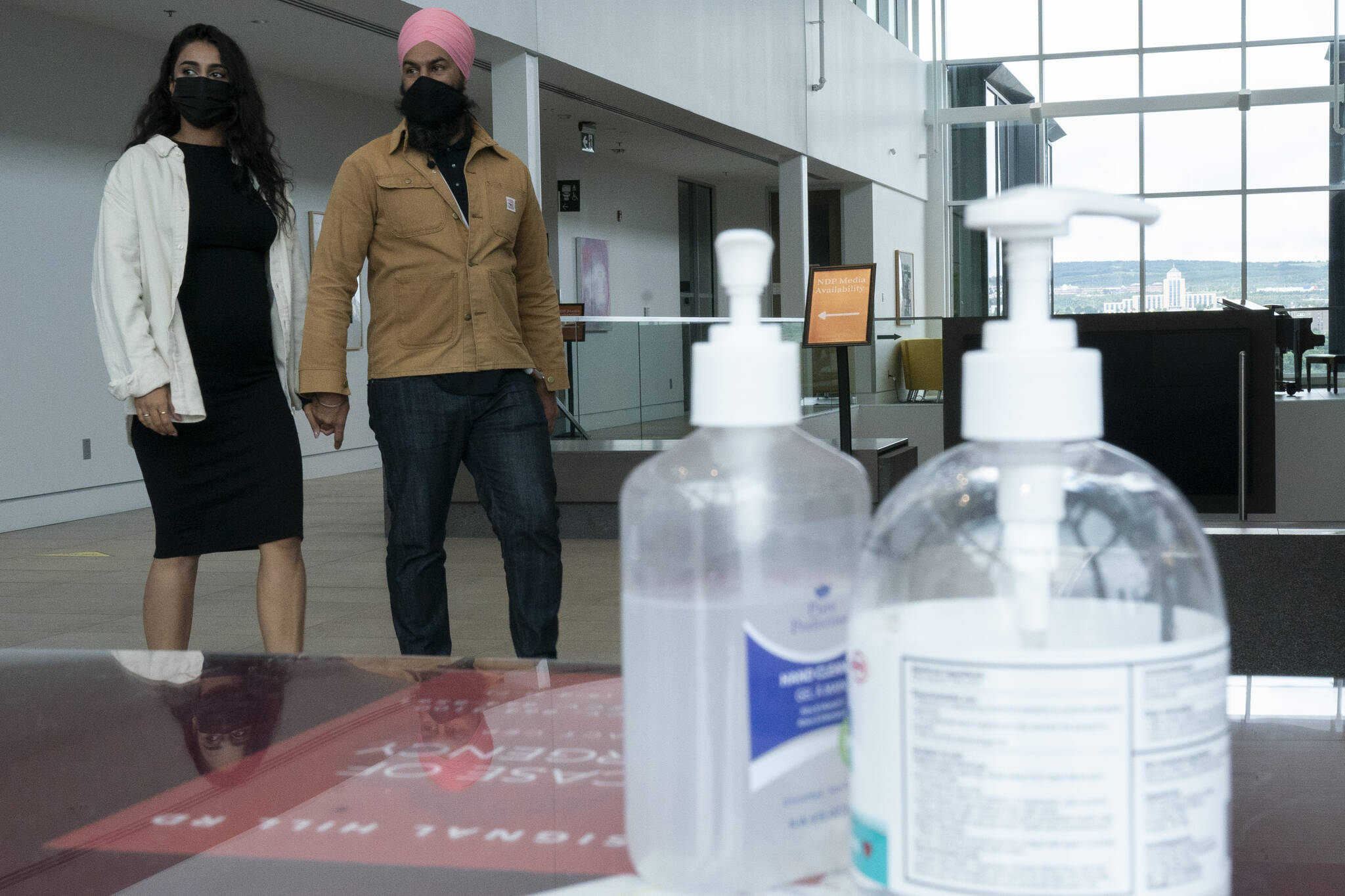 New Democratic Party Leader Jagmeet Jagmeet Singh and his wife Gurkiran Kaur Sidhu walk past hand sanitizer as they leave a campaign plane in St. John's, Saturday, Sept. 4, 2021. THE CANADIAN PRESS/Adrian Wyld