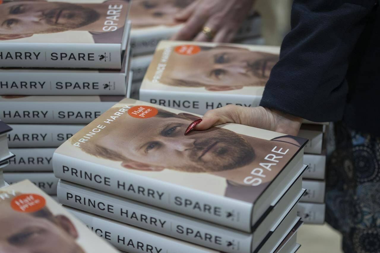 Members of staff place the copies of the new book by Prince Harry called “Spare” at a book store in London, Tuesday, Jan. 10, 2023. Prince Harry’s memoir “Spare” went on sale in bookstores on Tuesday, providing a varied portrait of the Duke of Sussex and the royal family. (AP Photo/Kin Cheung)