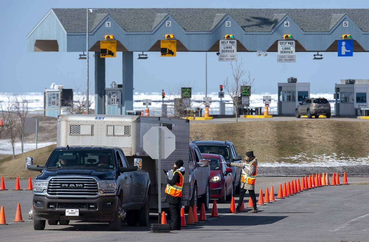 Provincial Health Department workers stop traffic that has crossed the Confederation Bridge in Borden-Carleton, P.E.I., Sunday, March 22, 2020. The premier of Prince Edward Island is asking the federal government to lower the tolls for the Confederation Bridge to make the trips to the mainland more affordable. THE CANADIAN PRESS/Andrew Vaughan