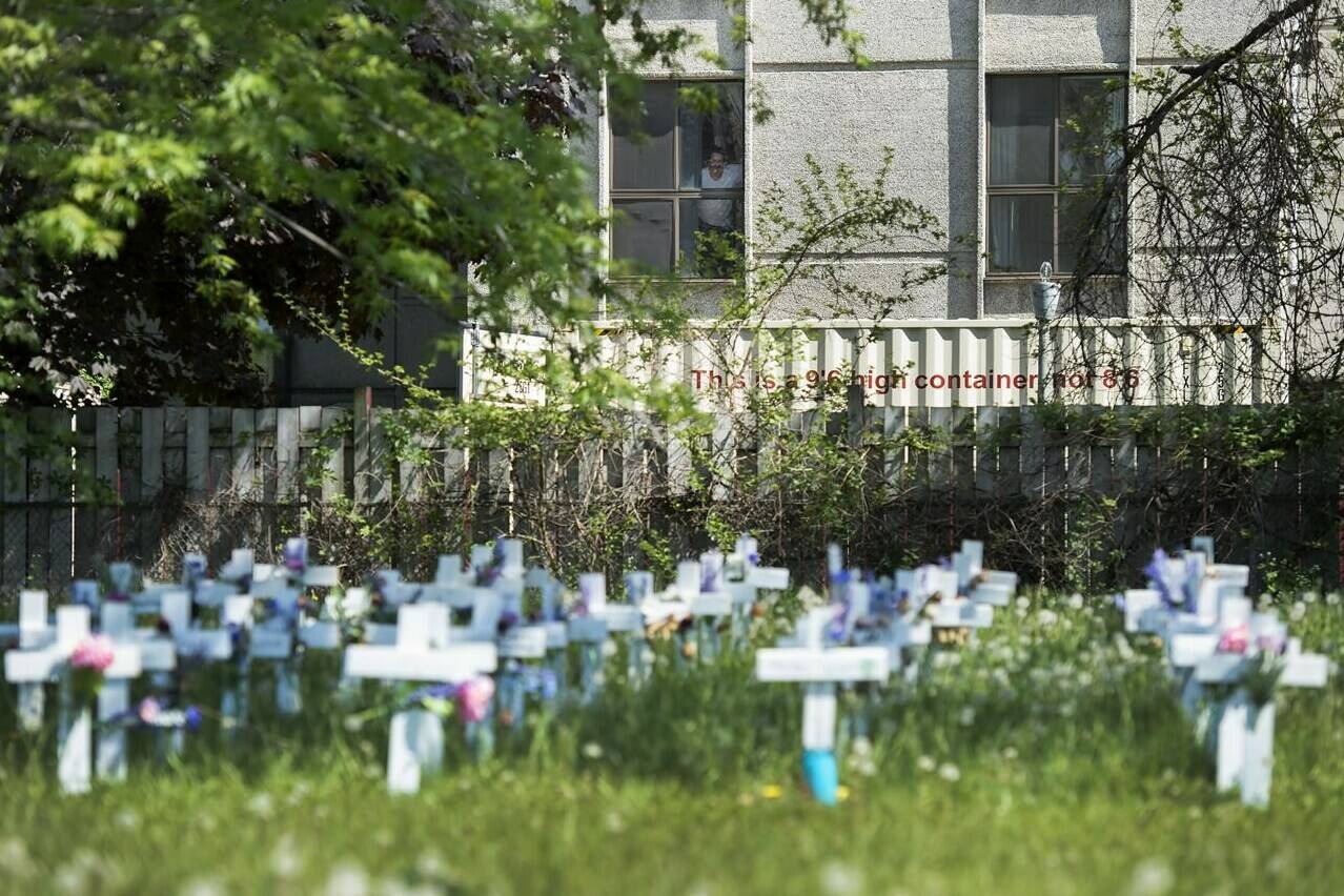 A team of experts have released a highly anticipated set of standards to prevent the spread of infection in Canada’s long-term care homes. A man looks out the window at the Camilla Care Community centre overlooking crosses marking the deaths of multiple people that occured during the COVID-19 pandemic in Mississauga, Ont., on Tuesday, May 26, 2020. THE CANADIAN PRESS/Nathan Denette