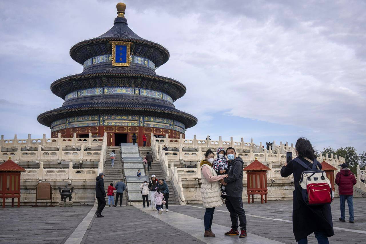 FILE - A family poses for photos at the Temple of Heaven in Beijing on Nov. 12, 2022. China has announced its first overall population decline in recent years amid an aging society and plunging birthrate. (AP Photo/Mark Schiefelbein, File)