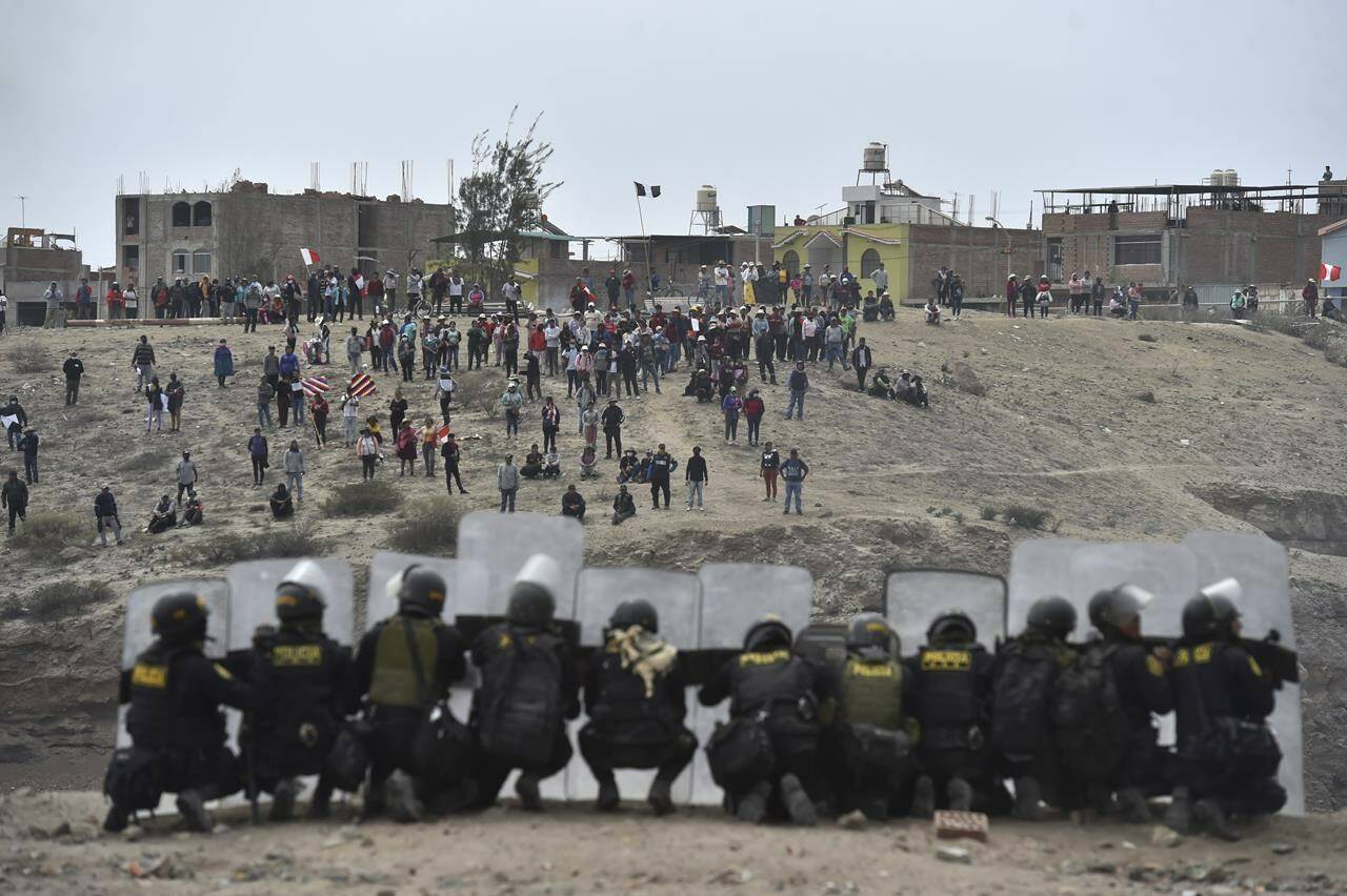 Anti-government protesters face off with security outside Alfredo Rodriguez Ballon airport in Arequipa, Peru, Thursday, Jan. 19, 2023. Protesters are seeking immediate elections, President Dina Boluarte’s resignation, the release of ousted President Pedro Castillo and justice for up to 48 protesters killed in clashes with police. (AP Photo/Jose Sotomayor)