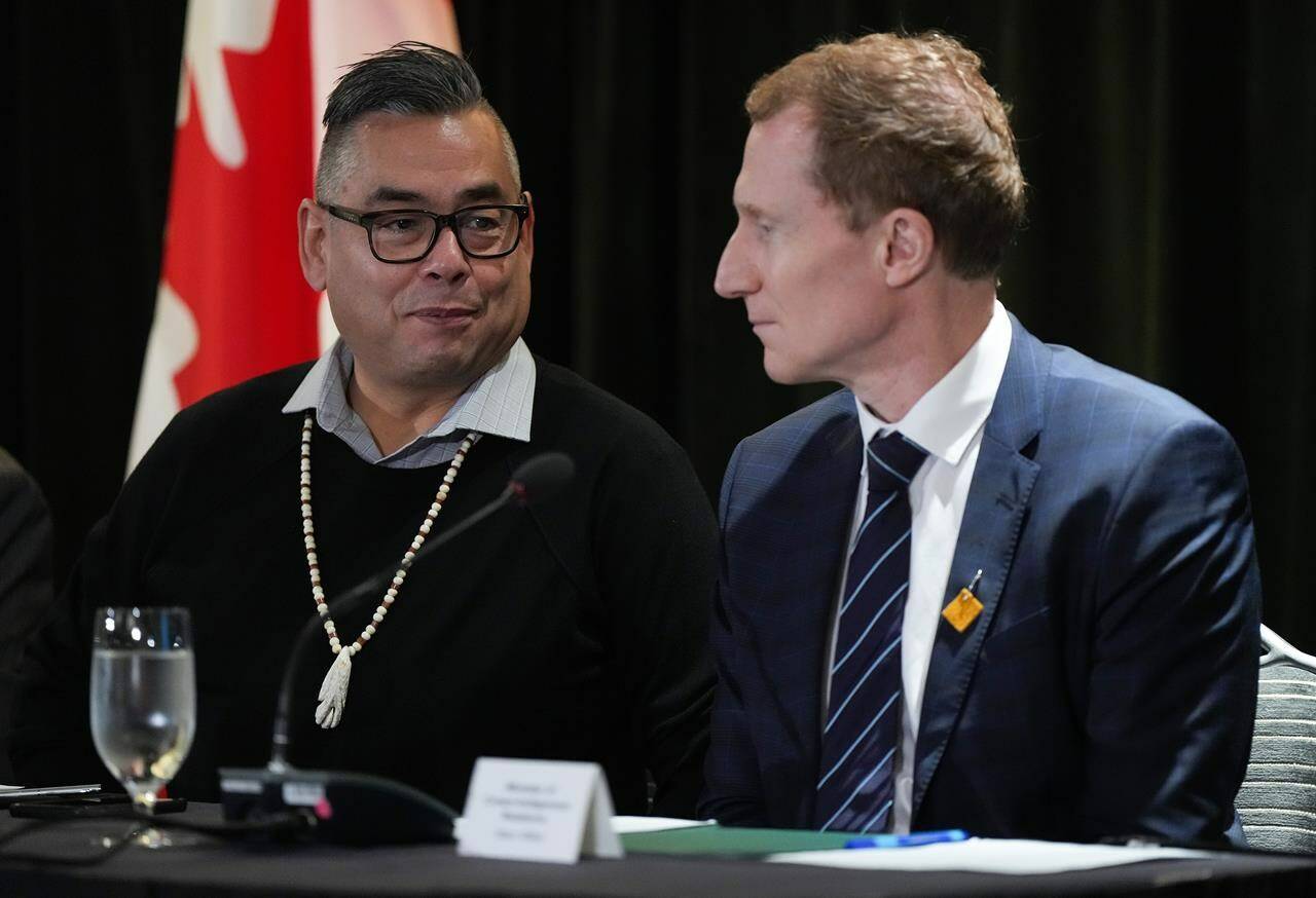 Former Tk'emlups te Secwepemc chief Shane Gottfriedson, left, and Minister of Crown-Indigenous Relations Marc Miller talk before a news conference, in Vancouver, on Saturday, January 21, 2023. The federal government says its come to a $2.8-billion agreement to settle a class-action lawsuit brought by two British Columbia first nations related to the collective harms caused by residential schools. The deal was signed with plaintiffs representing 325 members of the Gottfriedson Band that opted into the suit. THE CANADIAN PRESS/Darryl Dyck