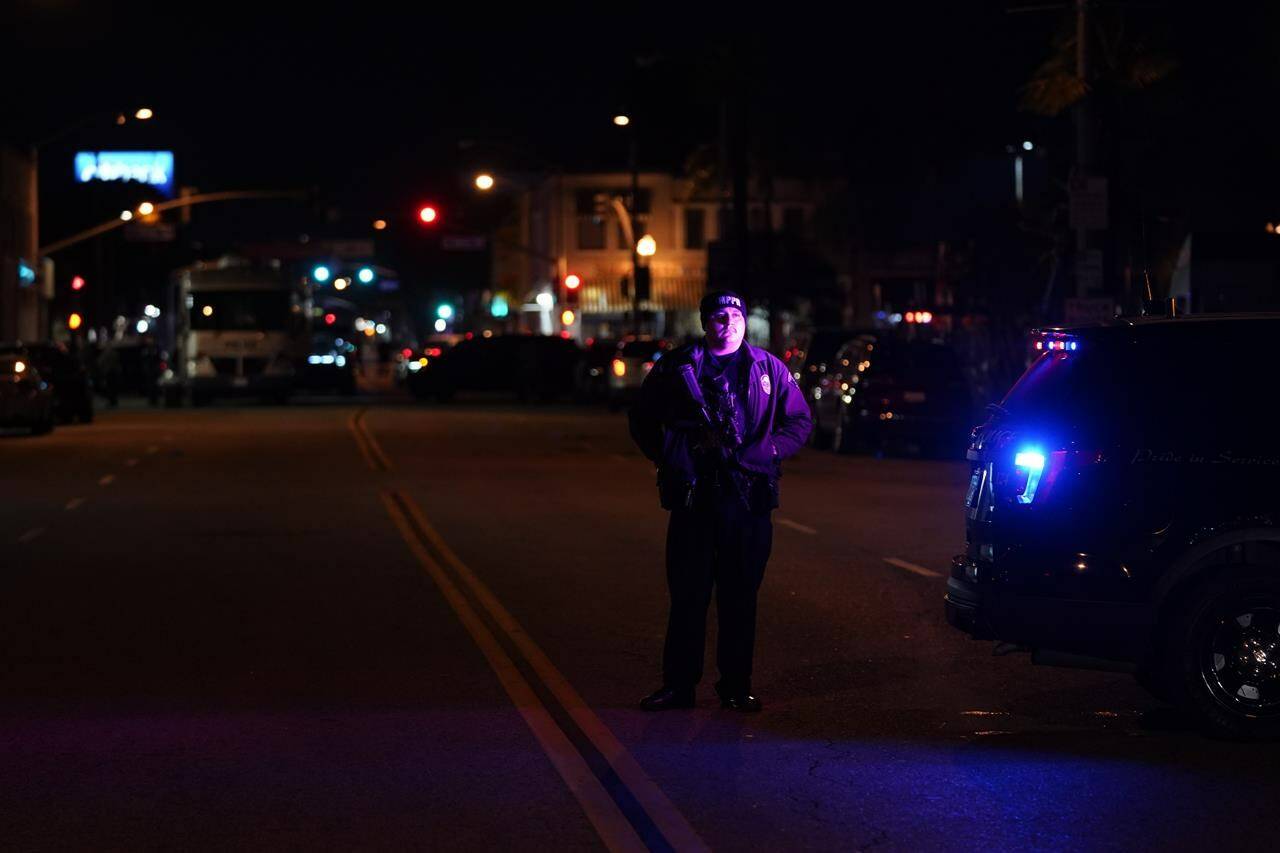 A police officer stands near a scene where a shooting took place in Monterey Park, Calif., Sunday, Jan. 22, 2023. Dozens of police officers responded to reports of a shooting that occurred after a large Lunar New Year celebration had ended in a community east of Los Angeles late Saturday. (AP Photo/Jae C. Hong)
