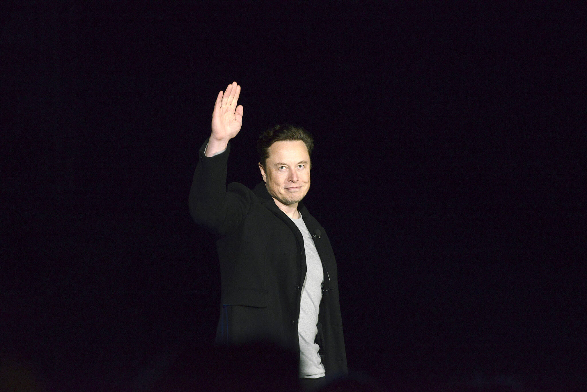 FILE - Elon Musk waves while providing an update on SpaceX’s Starship, Thursday, Feb. 10, 2022, near Brownsville, Texas. In April 2022, a group of Tesla shareholders suing Musk over some 2018 tweets about taking the company private is asking a federal judge to order him to stop commenting on the case. (Miguel Roberts/The Brownsville Herald via AP, File)
