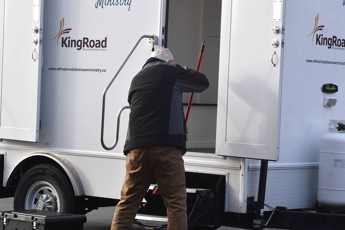 Henry Penner of Refresh Mobile Shower Ministry cleans the shower trailer before a cheque presentation in Abbotsford on Jan. 19. (Ben Lypka/Abbotsford News)