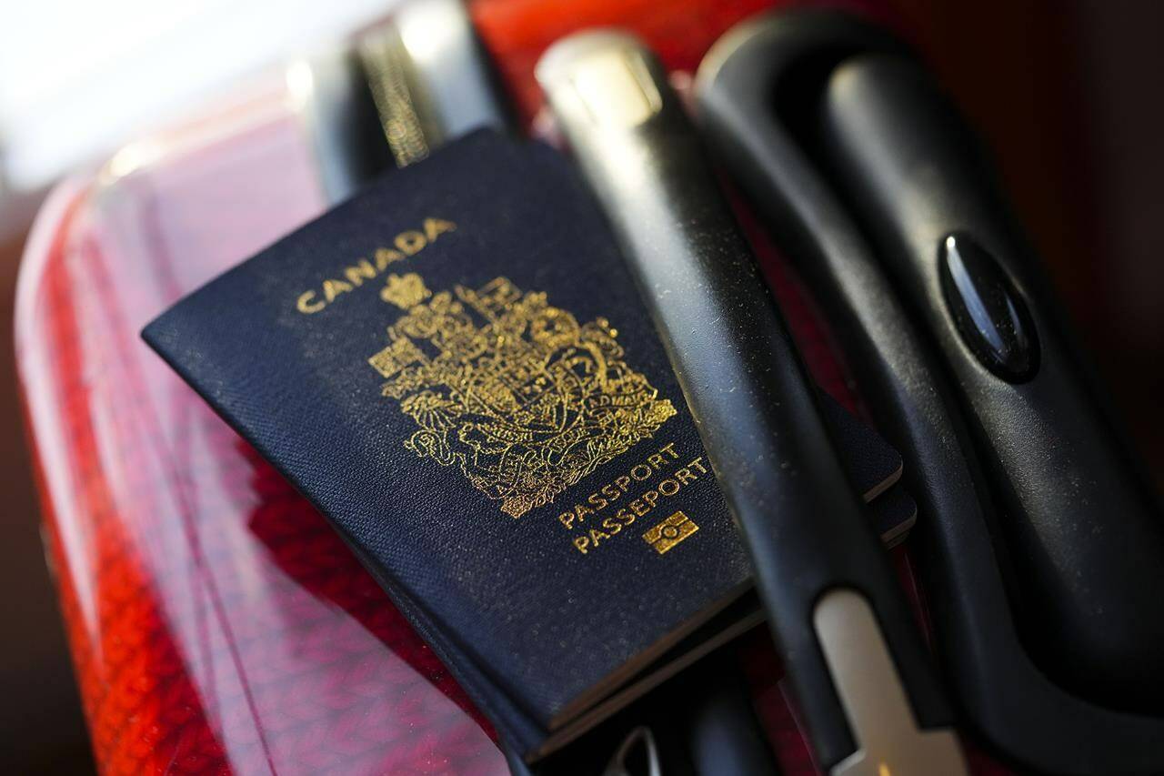 A Canadian passport sits on a suitcase in Ottawa on Tuesday, Jan. 17, 2023. Social Development Minister Karina Gould says Service Canada has “virtually eliminated” the backlog of thousands of passport applications. THE CANADIAN PRESS/Sean Kilpatrick