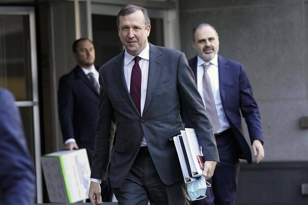 Nicholas Porritt, a lawyer representing Tesla shareholders in a class-action case, center, exits a federal courthouse in San Francisco, Monday, Jan. 23, 2023. (AP Photo/Jeff Chiu)