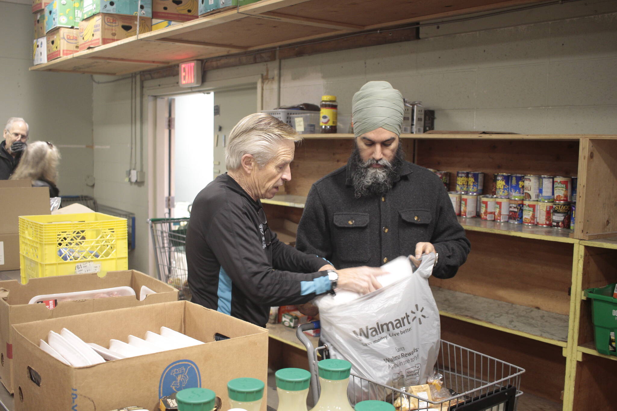 Campbell River food bank volunteer Bob Naylor helps federal NDP leader Jagmeet Singh fill a bag of food for a food bank client during Singh’s visit to Campbell River on Jan. 23. Photo by Marc Kitteringham/Campbell River Mirror