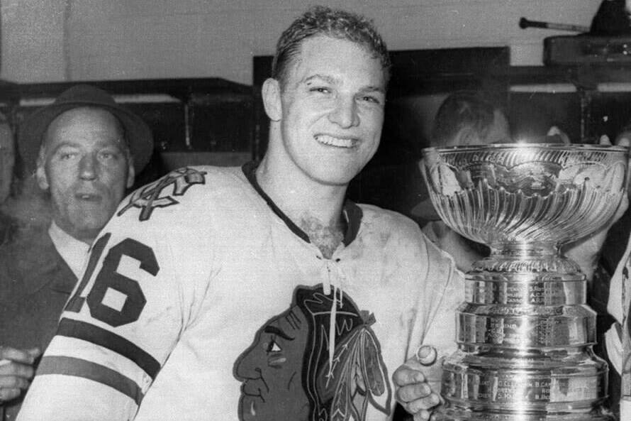 In this April 16, 1961, file photo, Chicago Blackhawks hockey player Bobby Hull smiles in the dressing room beside the Stanley Cup after Chicago defeated the Detroit Red Wings, 5-1, to win the NHL Championship, in Detroit. THE CANADIAN PRESS/AP