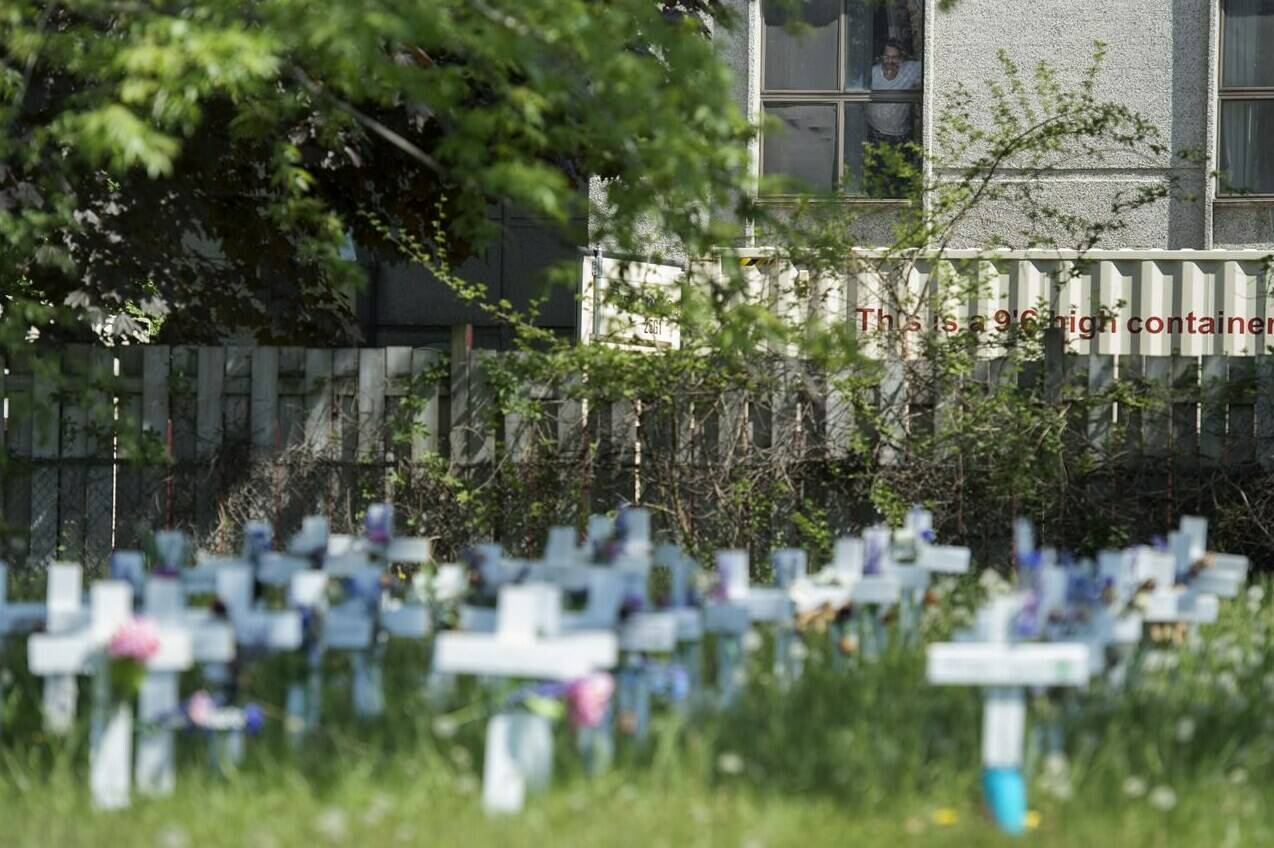 A panel of experts with the Health Standards Organization has developed updated guidance for how care homes should operate in light of the deadly and tragic toll the pandemic took on Canadian residents and their quality of life. A man looks out the window at the Camilla Care Community centre overlooking crosses marking the deaths of multiple people that occurred during the COVID-19 pandemic in Mississauga, Ont., on May 26, 2020. THE CANADIAN PRESS/Nathan Denette