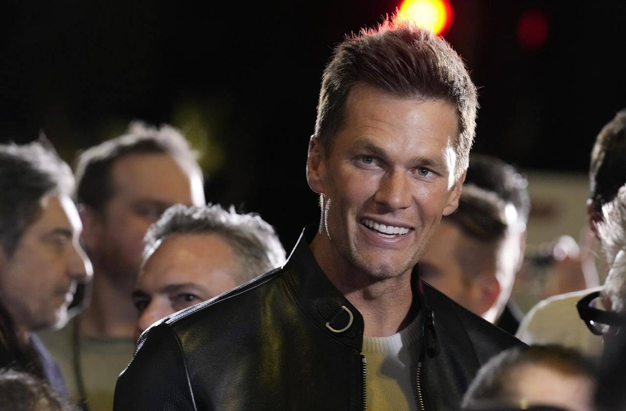 NFL quarterback Tom Brady, a cast member and producer of “80 for Brady,” looks down the carpet at the premiere of the film, Tuesday, Jan. 31, 2023, at the Regency Village Theatre in Los Angeles. (AP Photo/Chris Pizzello)