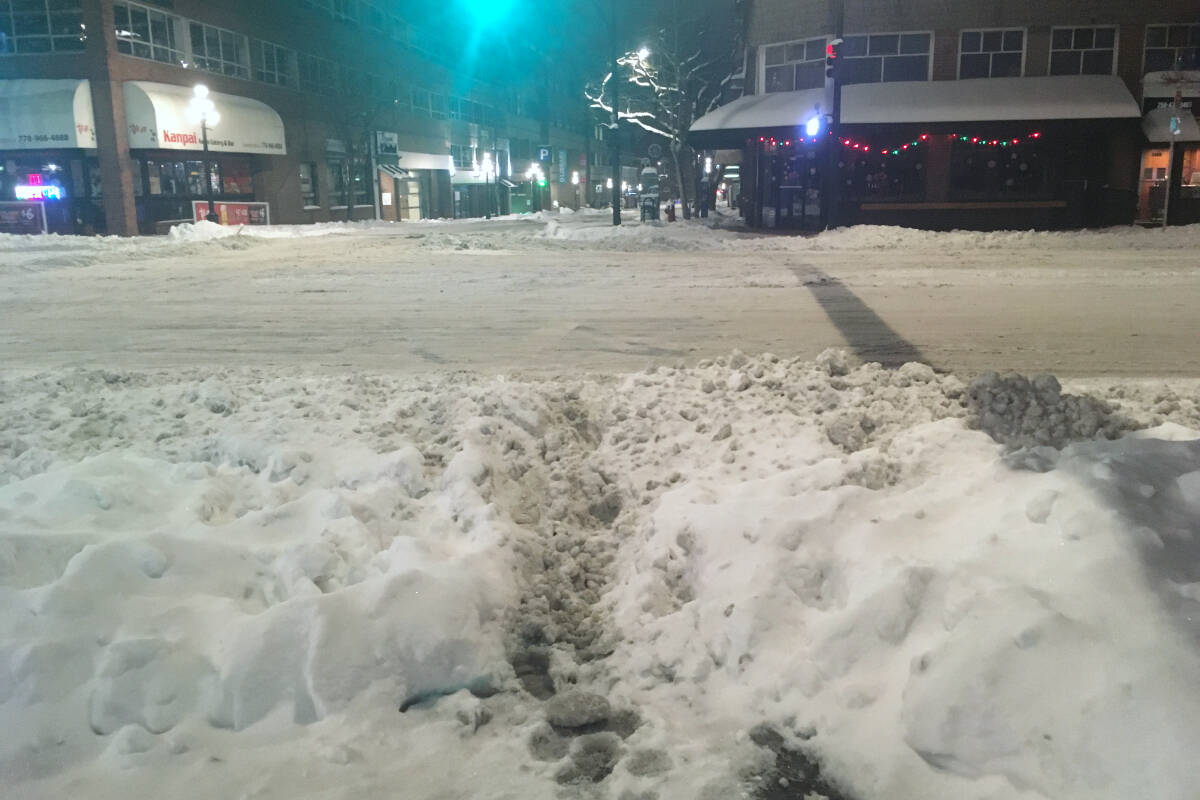 The signal says walk, but piles of icy snow say otherwise at the corner of Blanshard and Broughton in Victoria after a December 2022 snowfall. (Black Press Media file photo)
