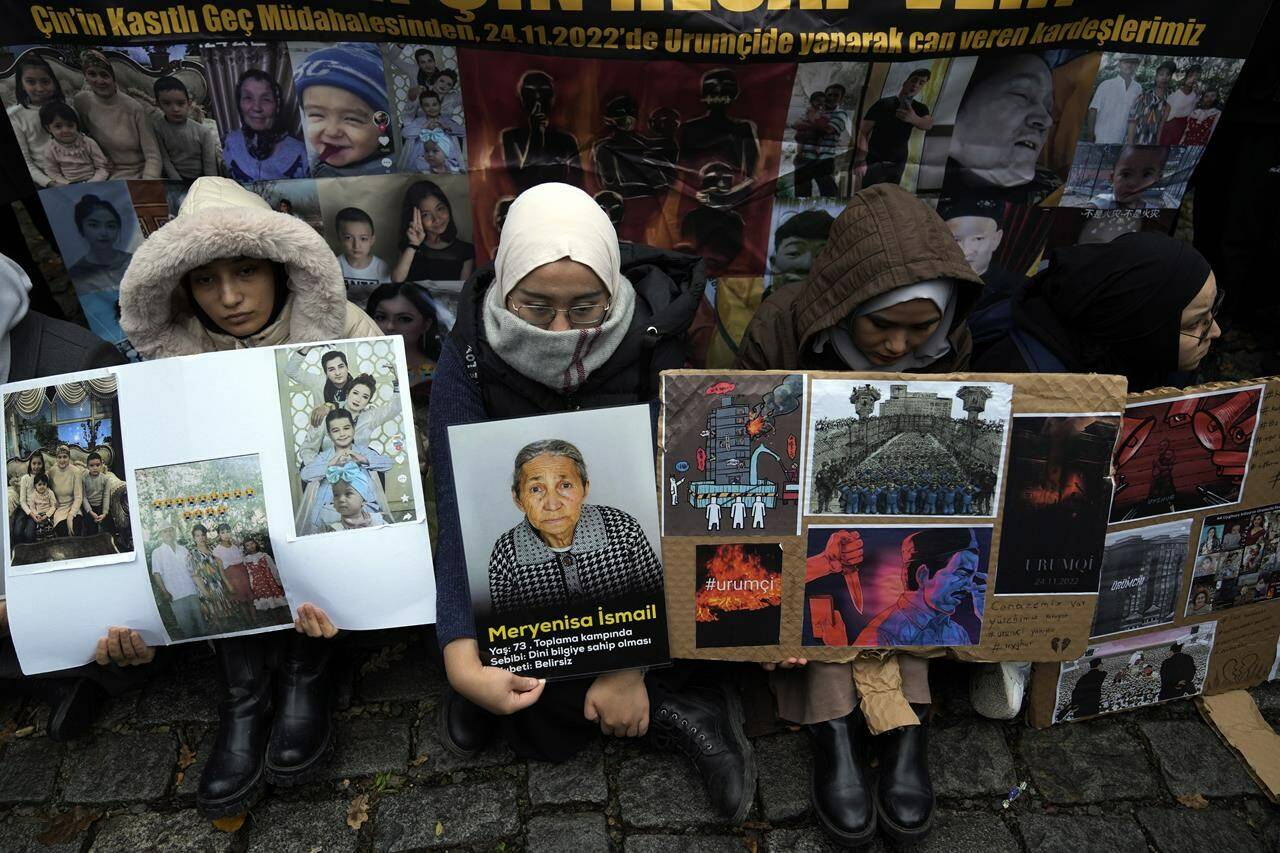 Women sit holding pictures of victims and posters reading “We have a funeral. Our hearts bleed. Urumqi (capital of China’s Xinjiang region) is burning”, in front of the Chinese consulate in Istanbul, Turkey, Wednesday, Nov. 30, 2022. MPs will vote this afternoon on whether to start a refugee program to resettle 10,000 Uyghurs fleeing persecution in China. THE CANADIAN PRESS- AP-Khalil Hamra