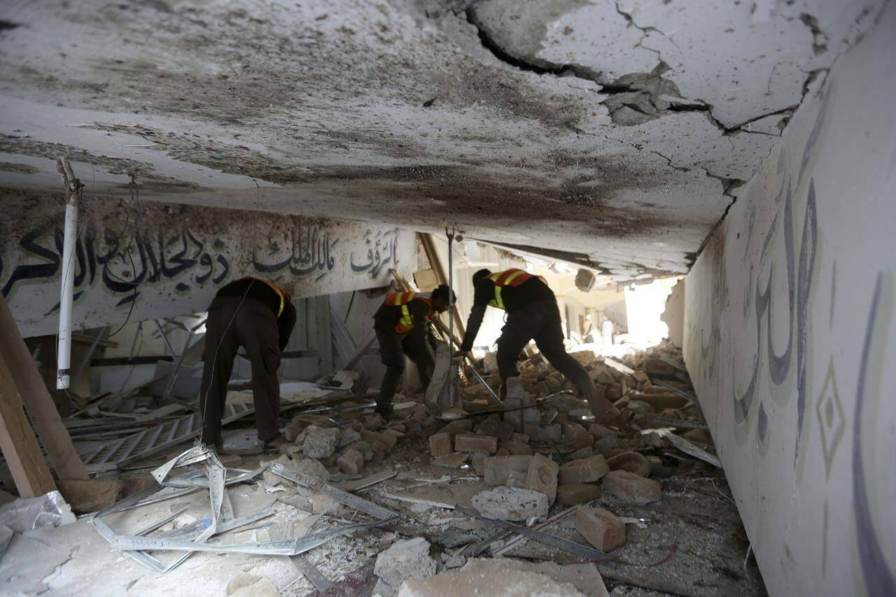 Rescue workers examine a damage portion at the site of Monday's suicide bombing after authorities finished the rescue operation, in Peshawar, Pakistan, Tuesday, Jan. 31, 2023. A suicide bombing that struck inside a mosque at a police and government compound in northwest Pakistan reflects "security lapses," current and former officials said as the death toll from the devastating blast climbed to 100 on Tuesday. (AP Photo/Muhammad Sajjad)