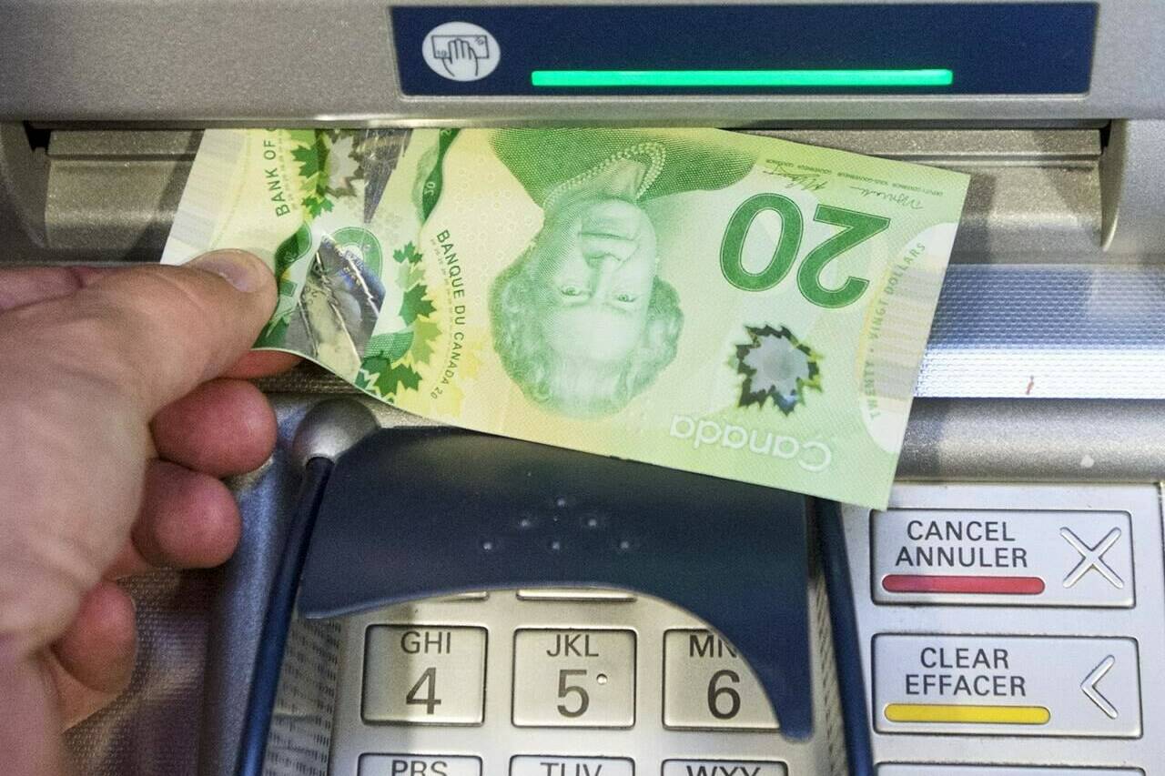 Money is removed from an ATM in Montreal, Monday, May 30, 2016. A new poll finds one-third of Canadian households say their financial situation has worsened over the last year. THE CANADIAN PRESS/Ryan Remiorz