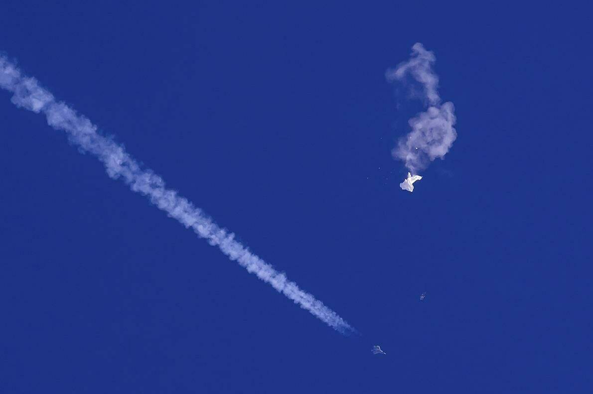 In this photo provided by Chad Fish, the remnants of a large balloon drift above the Atlantic Ocean, just off the coast of South Carolina, with a fighter jet and its contrail seen below it, Feb. 4, 2023. Canada and the United States are eyeing the sky with suspicion these days — as well as the shared continental defence system that’s supposed to be watching it for them. THE CANADIAN PRESS/AP-Chad Fish via AP, File