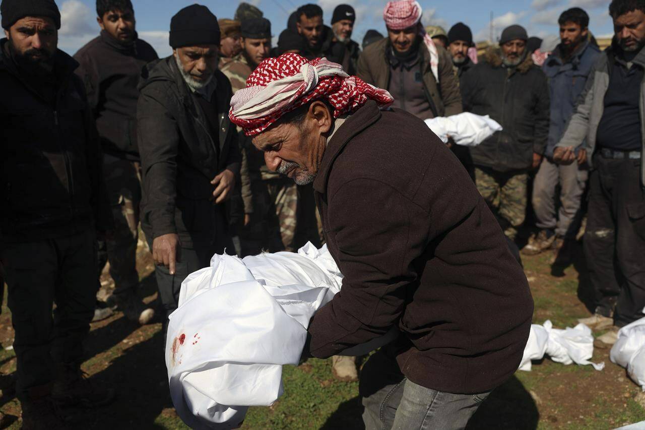 Mourners bury family members who died in a devastating earthquake that rocked Syria and Turkey at a cemetery in the town of Jinderis, Aleppo province, Syria, Tuesday, Feb. 7, 2023. A newborn girl was found buried under debris with her umbilical cord still connected to her mother, Afraa Abu Hadiya, who was found dead, according to relatives and a doctor. The baby was the only member of her family to survive from the building collapse Monday in Jinderis, next to the Turkish border, Ramadan Sleiman, a relative, told The Associated Press. (AP Photo/Ghaith Alsayed)