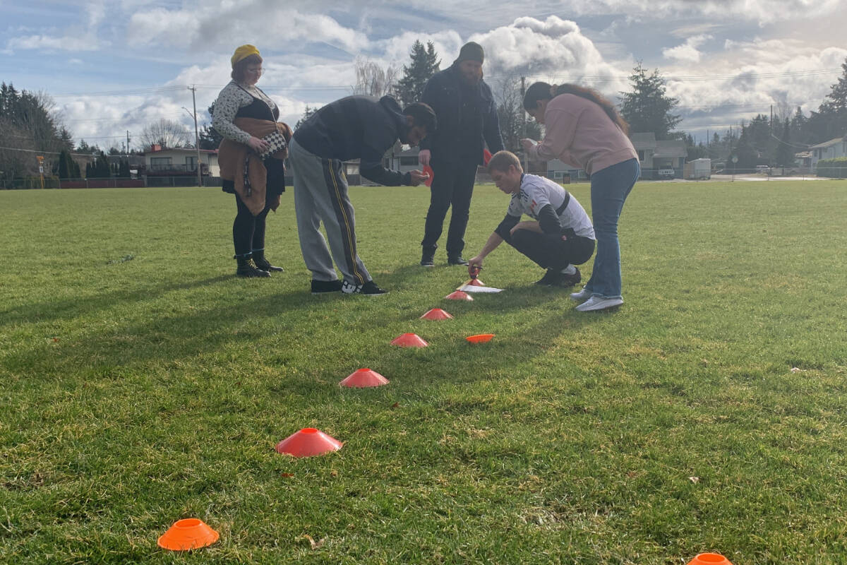 Daniel Mazey sets up the cones for his attempt to beat the Guinness Book of Records world record for the fastest 20-cone slalom dribbling a soccer ball. Each cone had to be exactly 50 cm apart. Photo by Terry Farrell