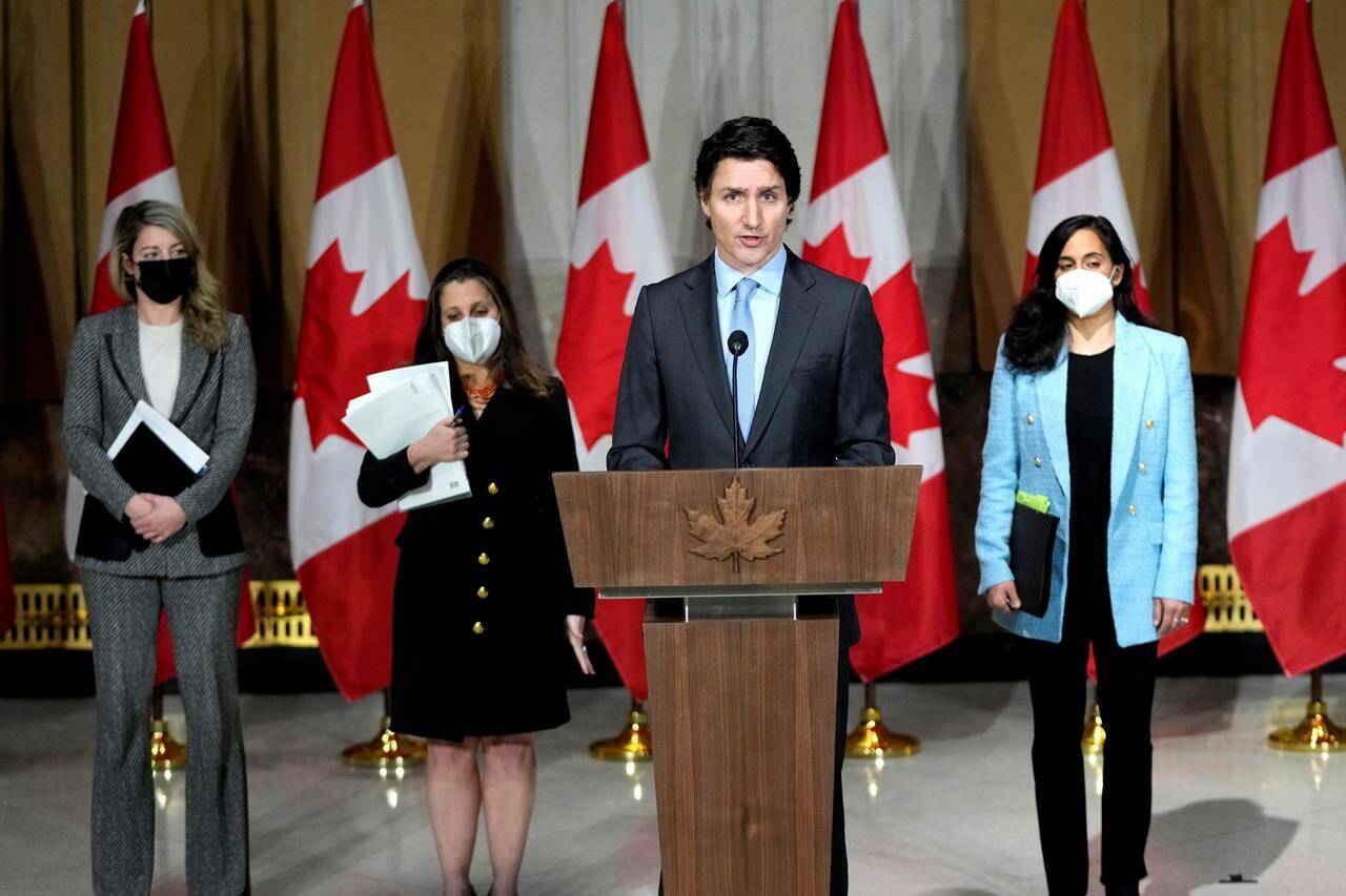 Prime Minister Justin Trudeau is joined by Minister of Foreign Affairs Melanie Joly, left, Deputy Prime Minister and Minister of Finance Chrystia Freeland, and Minister of National Defence Anita Anand, right, as he speaks during a media availability on the situation in Ukraine, in Ottawa, on Tuesday, Feb. 22, 2022. Nearly one year ago, Trudeau walked up to a podium in Ottawa, flanked by three of his top ministers, and declared the world had changed overnight. THE CANADIAN PRESS/Justin Tang