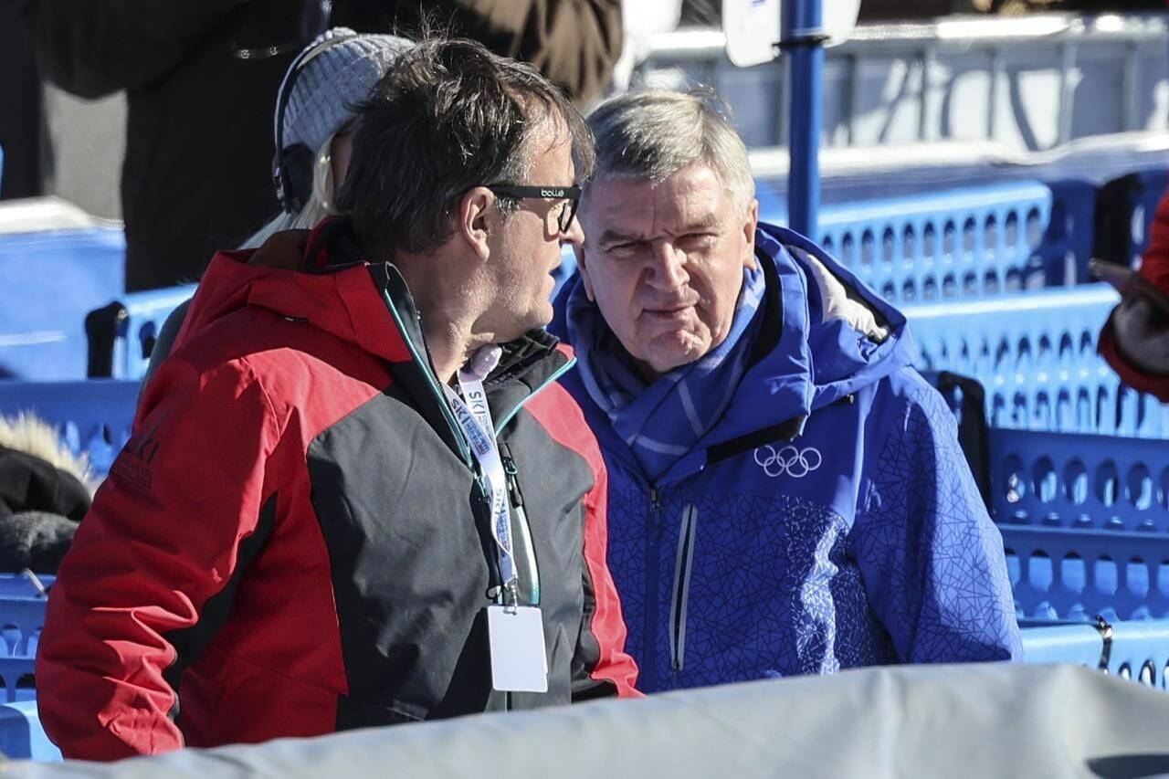 IOC (International Olympic Committee) President Thomas Bach, right, stands in the finish area of the alpine ski, men’s World Championship downhill, in Courchevel, France, Sunday, Feb. 12, 2023. (AP Photo/Marco Trovati)