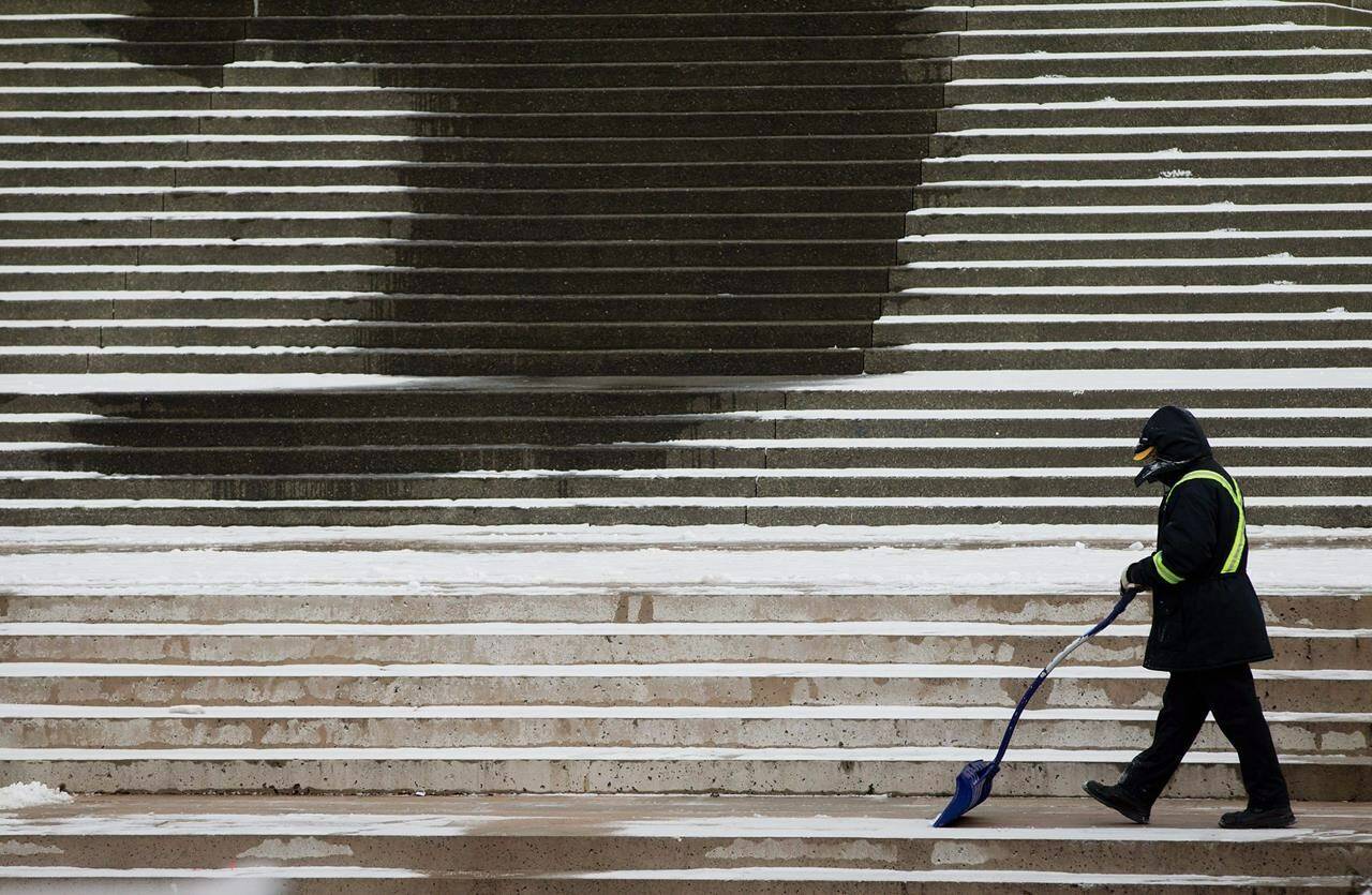 A bundled up worker shovels snow off steps during a cold morning in Vancouver, B.C., Wednesday, Jan. 18, 2012. Bitterly cold weather is gripping much of British Columbia and forecasters don’t expect conditions in some areas to ease until at least Thursday, while the threat of snow lies ahead for other regions. THE CANADIAN PRESS/Darryl Dyck