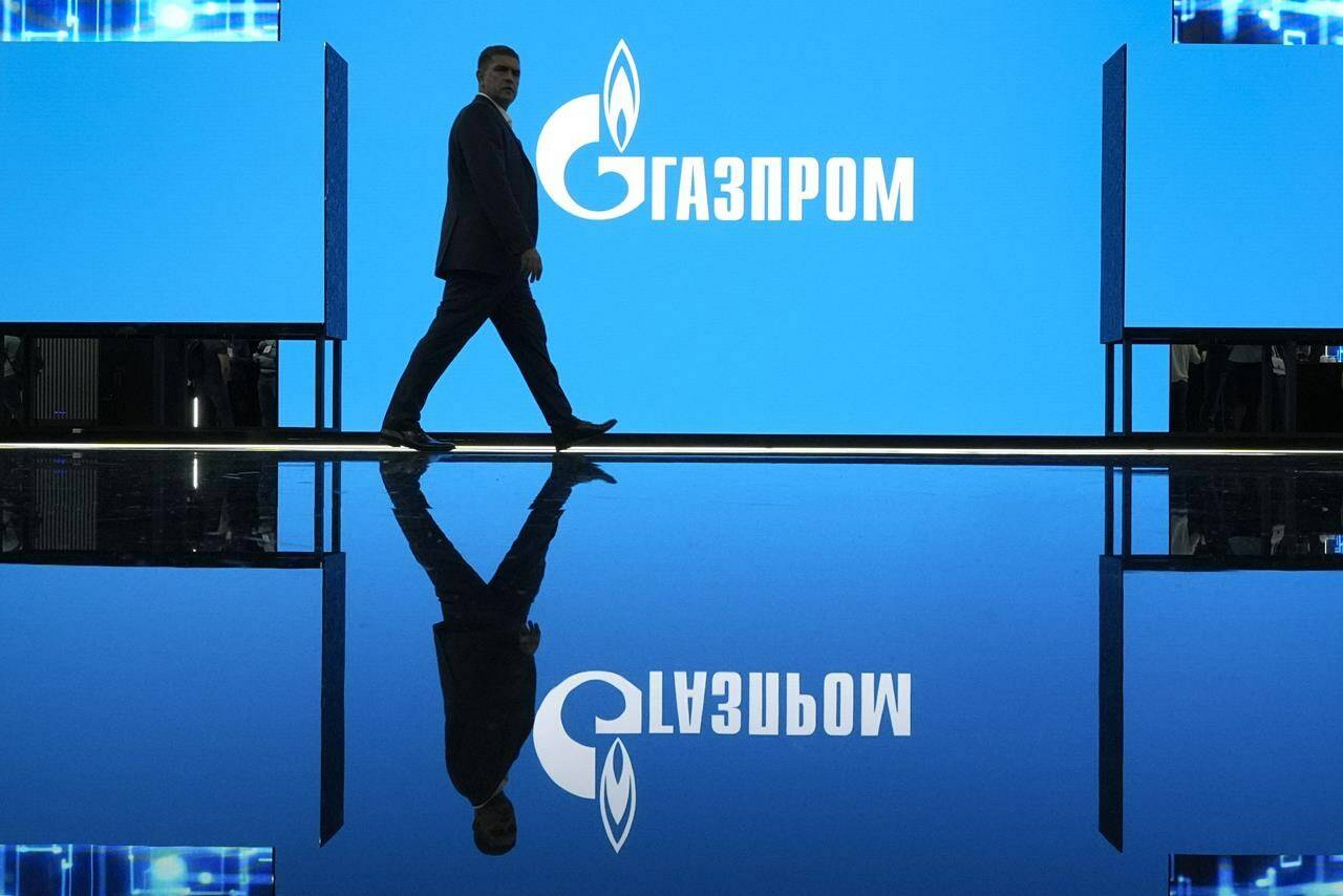 A man walks at an exhibition at the St. Petersburg International Gas Forum in St. Petersburg, Russia, Wednesday, Sept. 14, 2022, with a logo of Russian gas monopoly Gazprom in the background. Canada’s trade with Russia plummeted in the first 10 months after Moscow’s invasion of Ukraine a year ago, with Ottawa’s economic measures barring the export of everything from forklifts to barbers’ chairs. THE CANADIAN PRESS/AP-Dmitri Lovetsky