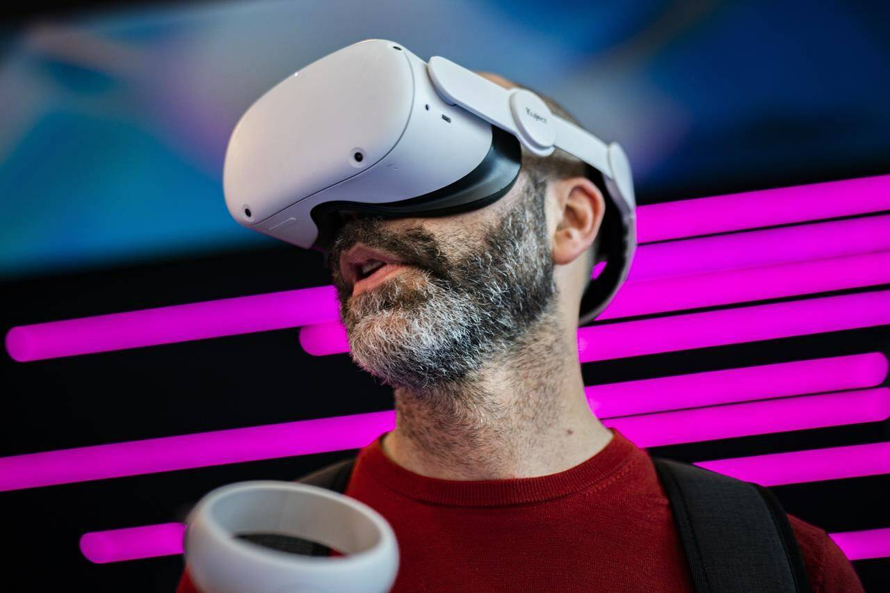 A visitor tests a GSMA VR simulator during the Mobile World Congress 2023 in Barcelona, Spain, Tuesday, Feb. 28, 2023. After three years of pandemic disruption, MWC, also known as Mobile World Congress, kicked off Monday in Barcelona, Spain, with mobile phone makers showing off new devices and telecom industry executives perusing the latest networking gear and software. (AP Photo/Joan Mateu Parra)