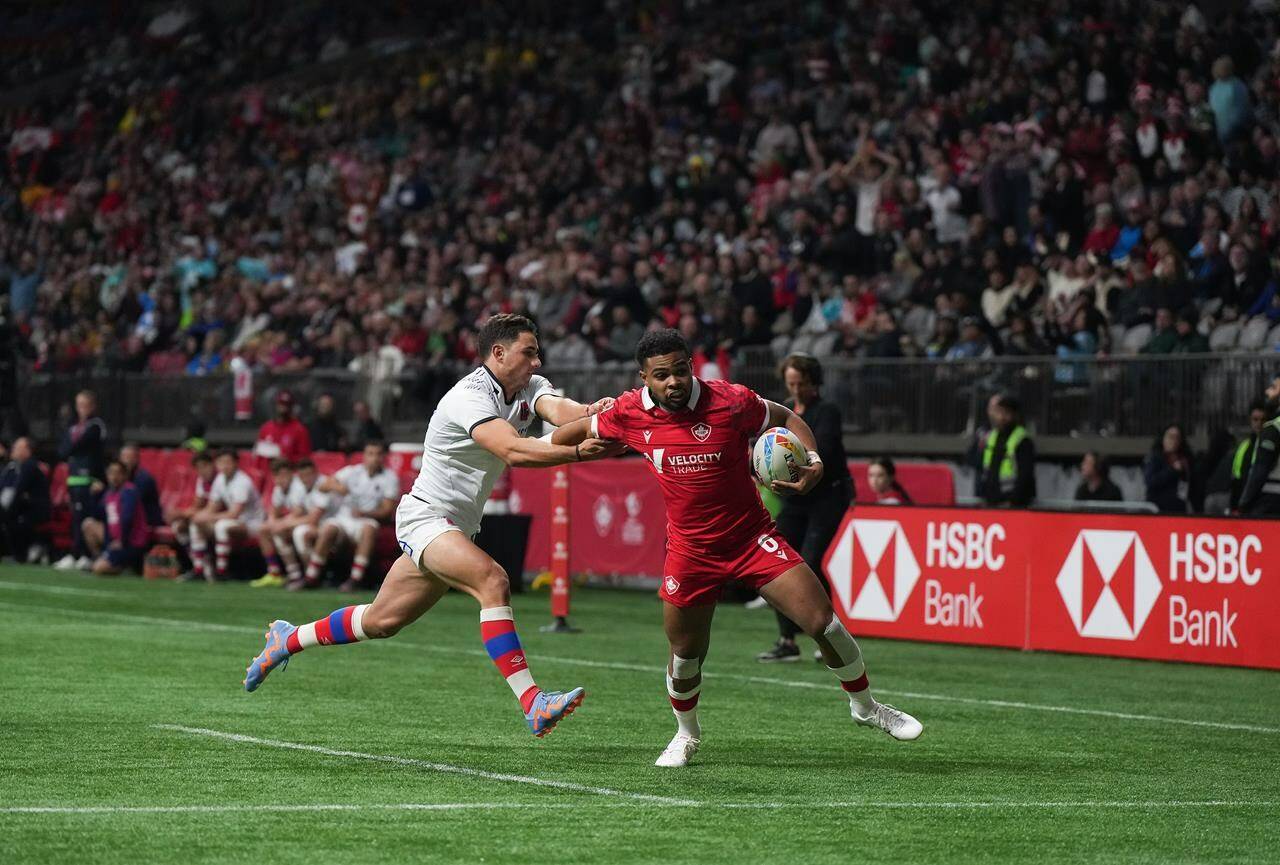 Canada’s Josiah Morra, right, fights off Chile’s Dante Marchese to score a try during HSBC Canada Sevens rugby action, in Vancouver, on Saturday, March 4, 2023. THE CANADIAN PRESS/Darryl Dyck