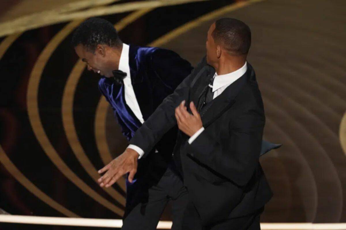 FILE - Will Smith, right, hits presenter Chris Rock on stage while presenting the award for best documentary feature at the Oscars on Sunday, March 27, 2022, at the Dolby Theatre in Los Angeles. Rock will be the first artist to perform on Netflix's first-ever live, global streaming event. (AP Photo/Chris Pizzello, File)