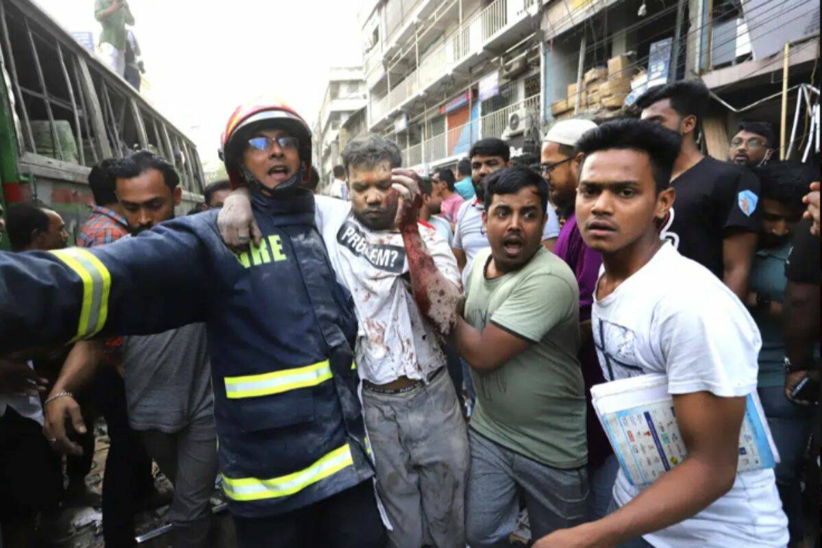 Fire officials and locals carry an injured person to hospital after an explosion, in Dhaka, Bangladesh, Tuesday, March 7, 2023. An explosion in a seven-story commercial building in Bangladesh's capital has killed at least 14 people and injured dozens. Officials say the explosion occurred in a busy commercial area of Dhaka. (AP Photo)