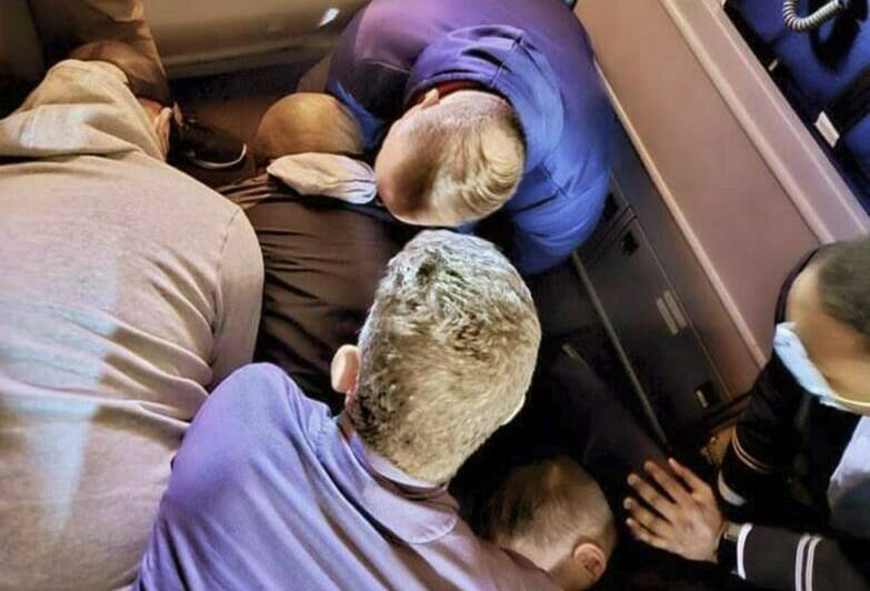 This image provided by Simik Ghookasian shows passengers and crew members restraining a man who according to federal authorities tried to open an airliner’s emergency door and tried to stab a flight attendant on a weekend flight from Los Angeles to Boston on Sunday, March 5, 2023. Simik Ghookasian, a passenger, said in a telephone interview that he was seated several rows behind the suspect, identified by federal authorities as Francisco Severo Torres, when he heard a commotion. (Simik Ghookasian via AP)