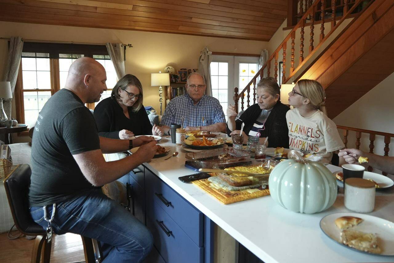 Doug Whitney, center, eats breakfast with his family in Manson, Wash., on Nov. 5, 2022. Whitney inherited the same gene mutation that gave Alzheimer’s disease to his mother, brother and generations of other relatives by the unusually young age of 50. Doug is a healthy 73, his mind still sharp. Somehow, he escaped his genetic fate. (AP Photo/Shelby Lum)