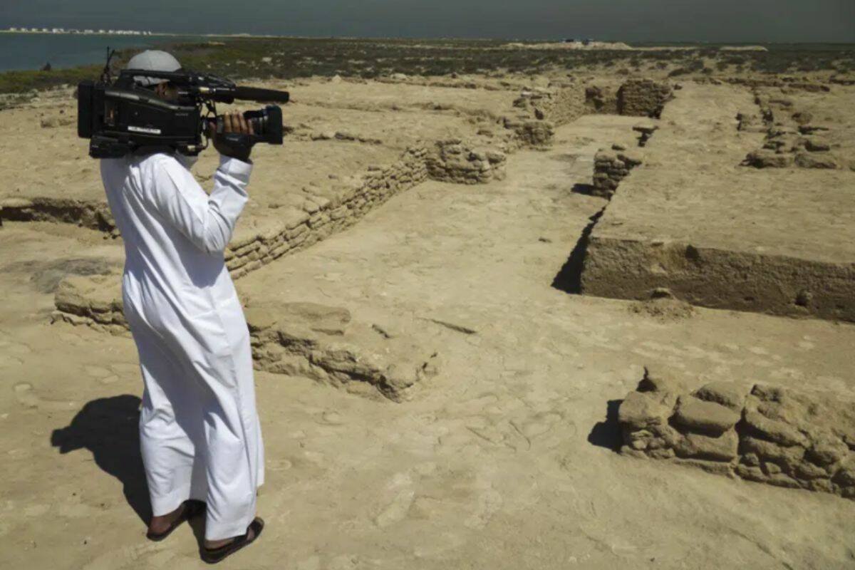 A journalist films uncovered ruins on Siniyah Island in Umm al-Quwain, United Arab Emirates, Monday, March 20, 2023. Archaeologists said Monday they have found the oldest pearling town in the Persian Gulf on an island off one of the northern sheikhdoms of the United Arab Emirates. (AP Photo/Jon Gambrell)