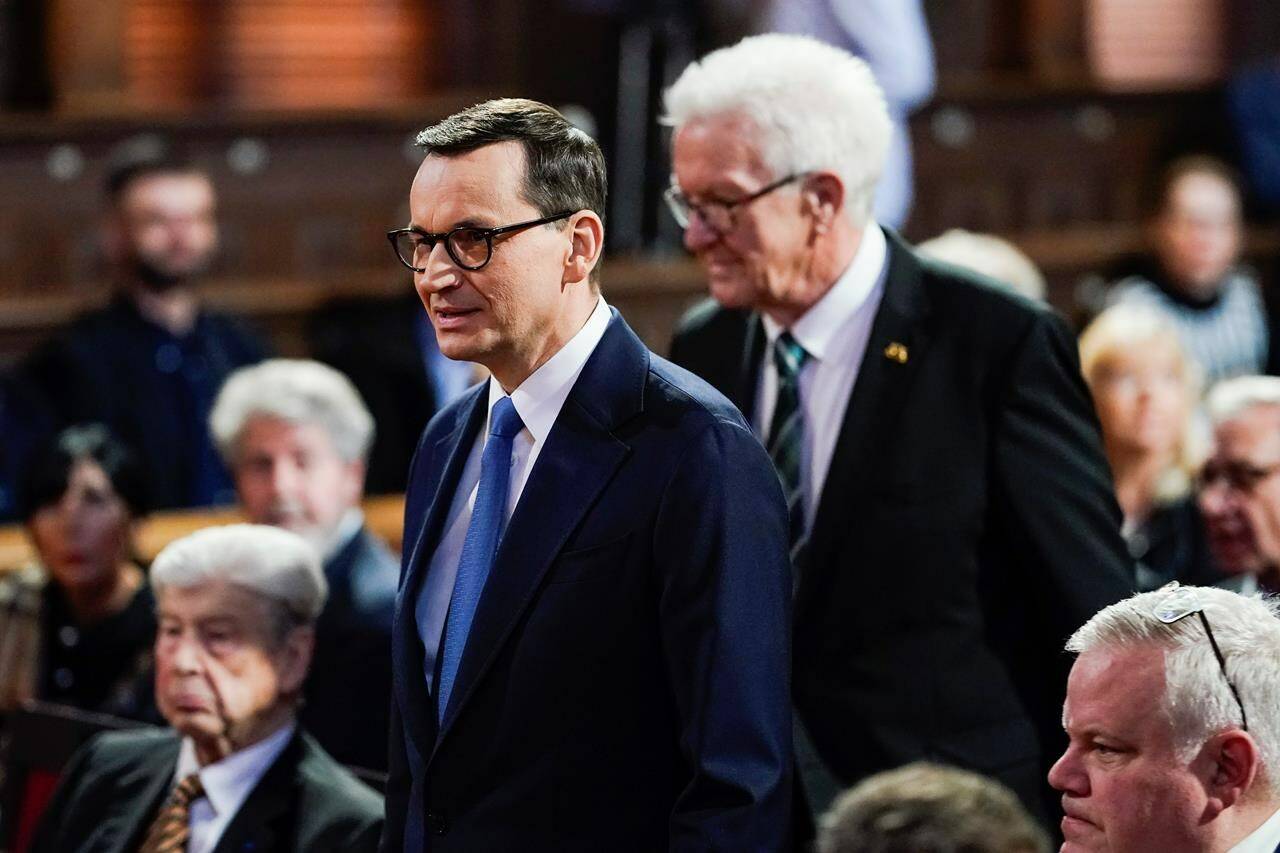 Poland’s Prime Minister Mateusz Morawiecki, left, arrives with the Prime Minister of German federal state baden Württemberg Winfried Kretschmann, right, at the Old Assembly Hall to deliver his speech about the ‘Future Of Europe’ at the University in Heidelberg, Germany, Monday, March 20, 2023. (Uwe Anspach/dpa via AP)