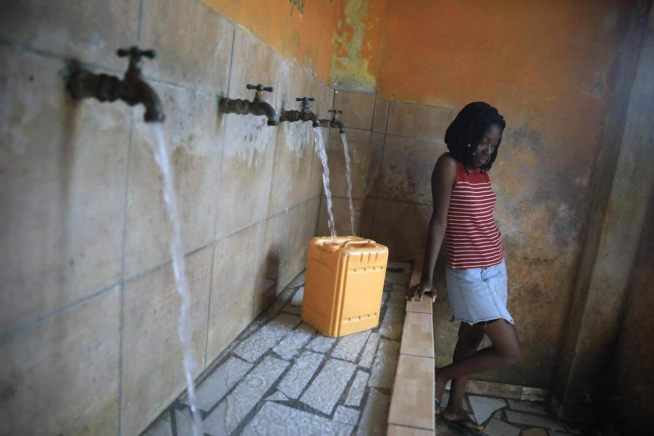 A resident without running water at home fills a container at a water fill station, a day ahead of World Water Day, in Port-au-Prince, Haiti, Tuesday, March 21, 2023. (AP Photo/Odelyn Joseph)