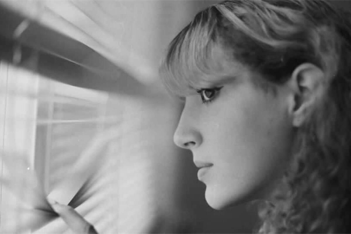 Olivia Hahn, 16, peers through the blinds into the daylight outside. (Courtesy of John Hahn)