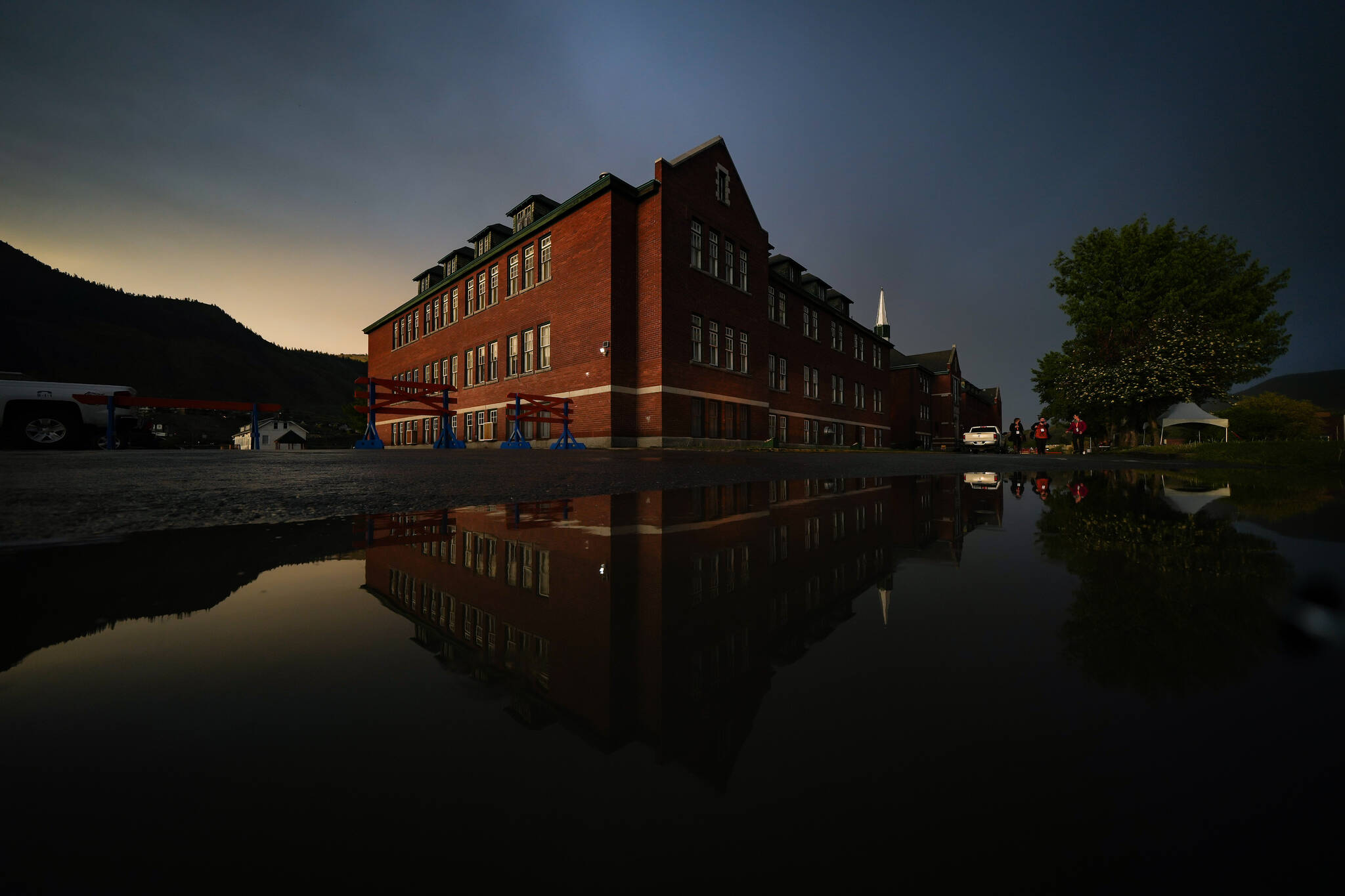 The former Kamloops Indian Residential School is seen at sunset after a rainstorm and a day-long ceremony to mark the one-year anniversary of the Tk’emlups te Secwepemc announcement of the detection of the remains of 215 children at an unmarked burial site at the former residential school, in Kamloops, B.C., on Monday, May 23, 2022. THE CANADIAN PRESS/Darryl Dyck