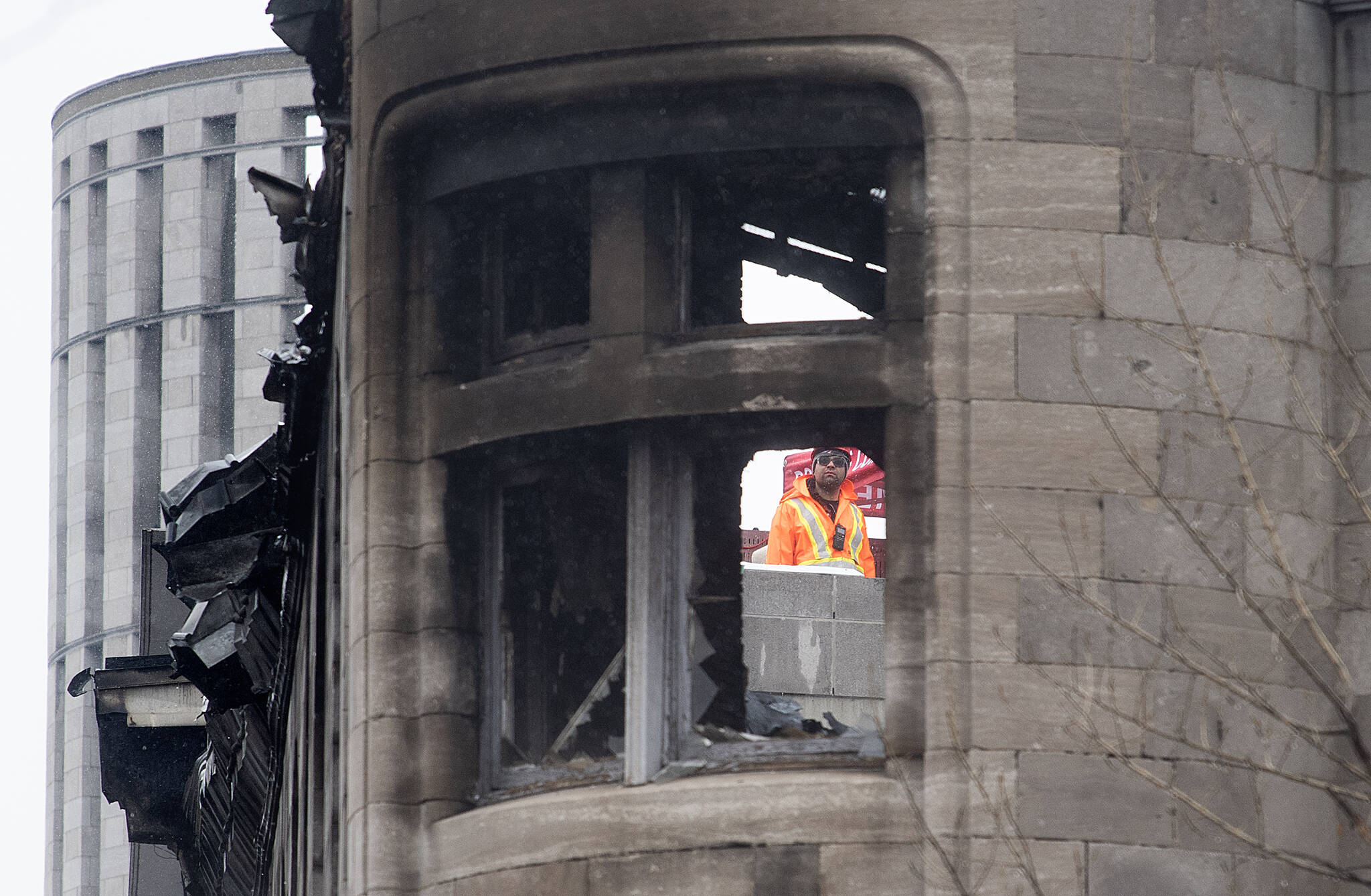 A worker is shown next to a building that was gutted by a fire in Montreal, Thursday, March 23, 2023. The heritage building went up in flames last week. Four bodies have been recovered and three people remain missing. THE CANADIAN PRESS/Graham Hughes