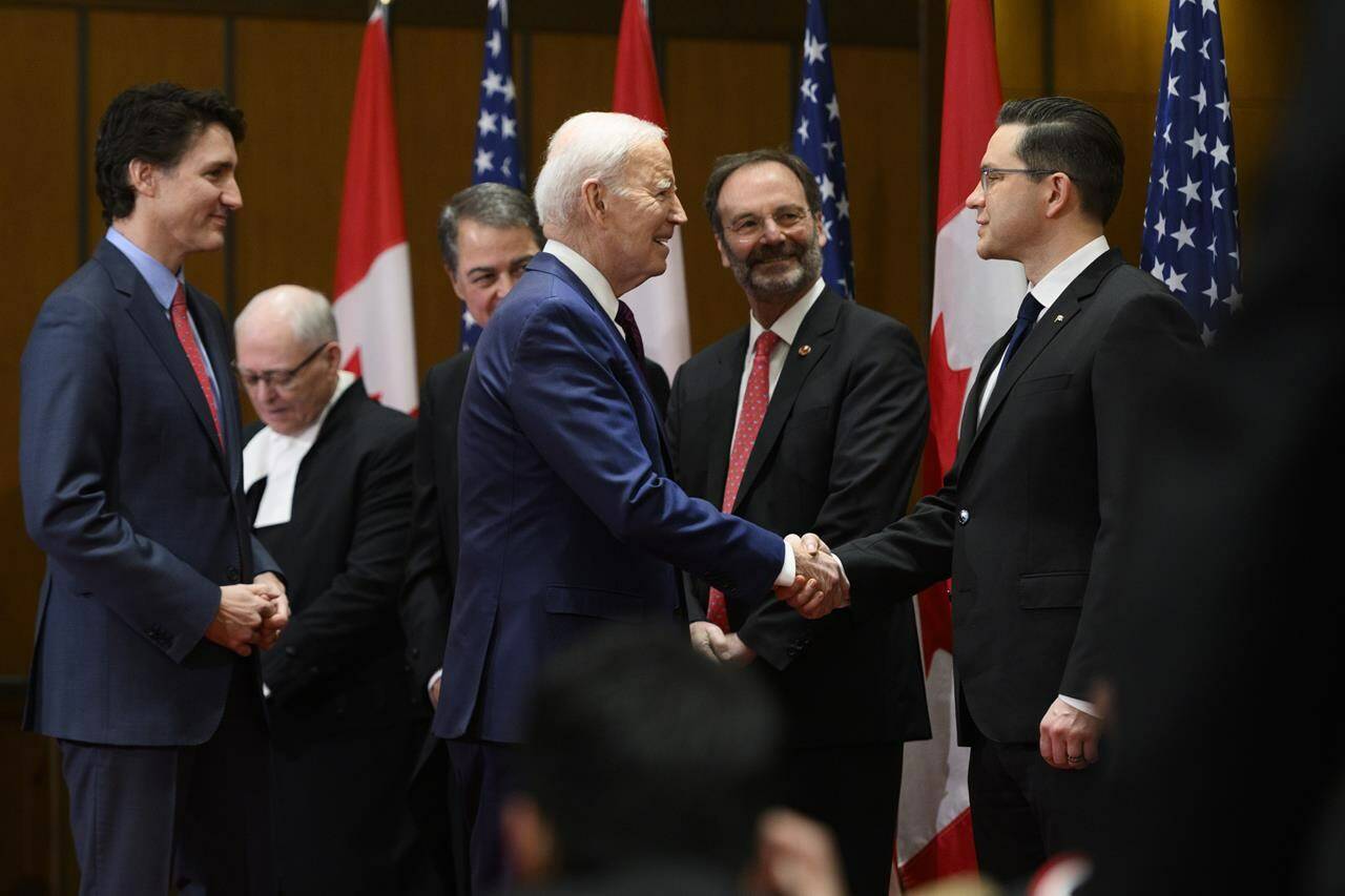 U.S. President Joe Biden shakes hands with Conservative Party of Canada Leader Pierre Poilievre, as Prime Minister Justin Trudeau looks on, during a welcoming ceremony on Parliament Hill in Ottawa, on Friday, March 24, 2023. Conservative Leader Pierre Poilievre says allowing Canadians who are unvaccinated against COVID-19 to cross into the United States was among issues he raised with President Joe Biden. THE CANADIAN PRESS/Justin Tang
