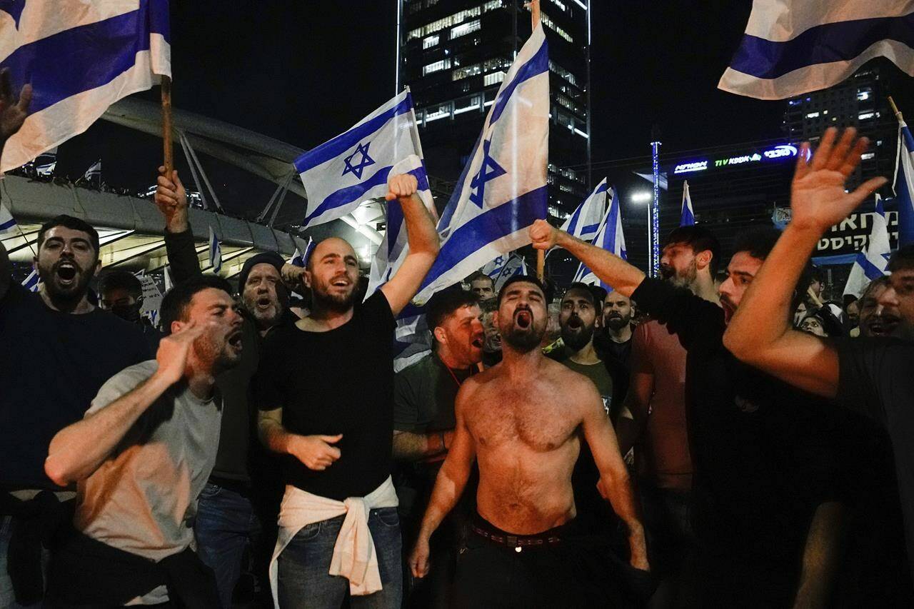 Israelis opposed to Prime Minister Benjamin Netanyahu’s judicial overhaul plan block a highway during a protest moments after the Israeli leader fired his defense minister, in Tel Aviv, Israel, Sunday, March 26, 2023. Defense Minister Yoav Gallant had called on Netanyahu to freeze the plan, citing deep divisions in the country and turmoil in the military. (AP Photo/Ohad Zwigenberg)