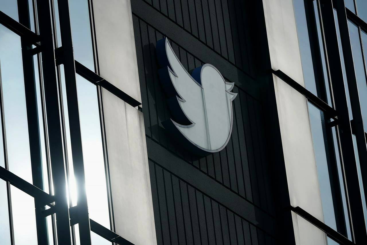 FILE - A Twitter logo hangs outside the company’s offices in San Francisco, on Dec. 19, 2022. William Shatner, Monica Lewinsky and other prolific Twitter commentators — some household names, others little-known journalists — could soon be losing the blue check marks that helped verify their identity on the social media platform. (AP Photo/Jeff Chiu, File)