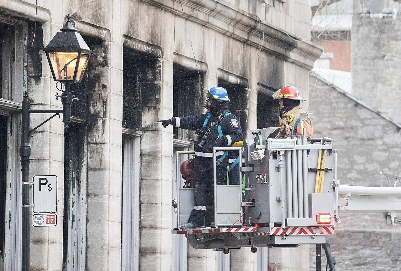 Investigators survey the scene following a fire in Old Montreal on Sunday, March 19, 2023, that gutted a heritage building. Several people are still unaccounted for. THE CANADIAN PRESS/Graham Hughes