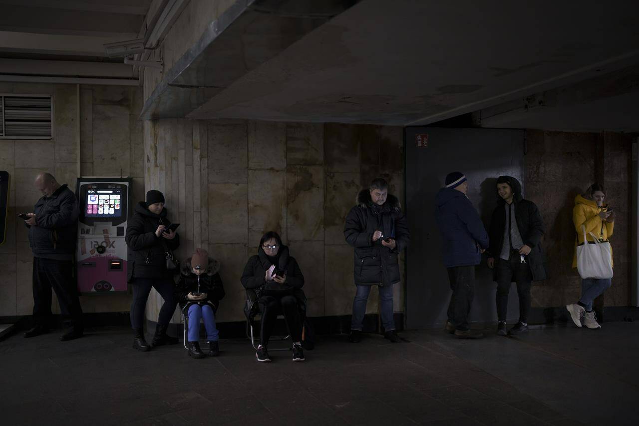 FILE - People use their phones while they gather in a metro station during an air raid alarm, in Kyiv, Ukraine, Wednesday, Dec. 21, 2022. When air raid alarms sound in Ukraine, they also trigger a downloadable app that has been voiced by “Star Wars” actor Mark Hamill. With his gravely but also calming baritone, he urges people to take cover. He also tells them when the danger has passed, signing off with “May the Force be with you.” In an interview with The Associated Press, the actor said he’s admiring Ukraine’s resilience from afar in California. (AP Photo/Felipe Dana, File)